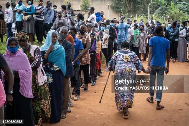 Voters queue at a polling station in Magere, Uganda, on January 14, 2021. - Ugandans lined up to vote in a tense election on January 14, 2021 under...