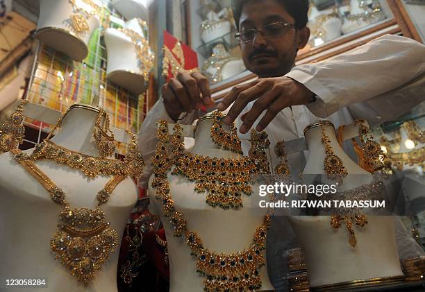 Pakistani man arranges jewelry as he waits for customers in his shop in Karachi on August 27 on the Muslims fasting holy month of Ramadan. Muslims...