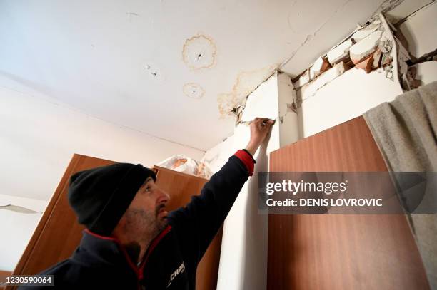 Josip Likevic shows a cracked wall inside his house, in the village of Sibic on 12 January that was badly damaged in a deadly quake that hit central...