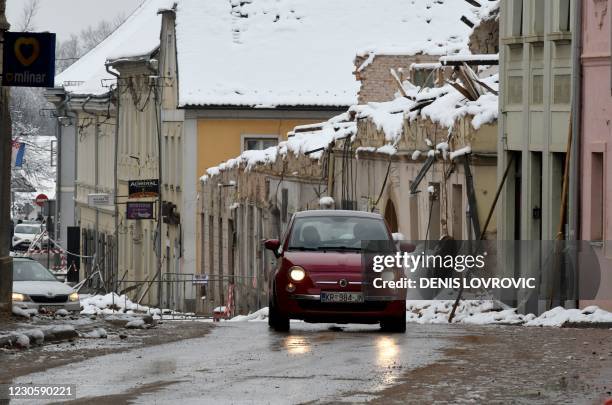 Car drives along a street in Petrinja on January 12 a town in central Croatia, that was struck by a deadly earthquake on December 29. - Winter shows...