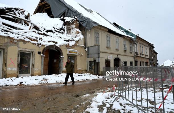 Man walks on a snow covered street of the central Croatian town of Petrinja on January 12 that was struck by a deadly earthquake on December 29. -...