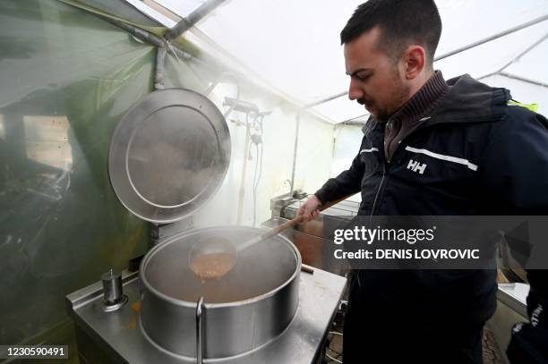 Volunteer cooks beans in a tent in Petrinja on January 12 a town in central Croatia, that was struck by a deadly earthquake on December 29. - Winter...