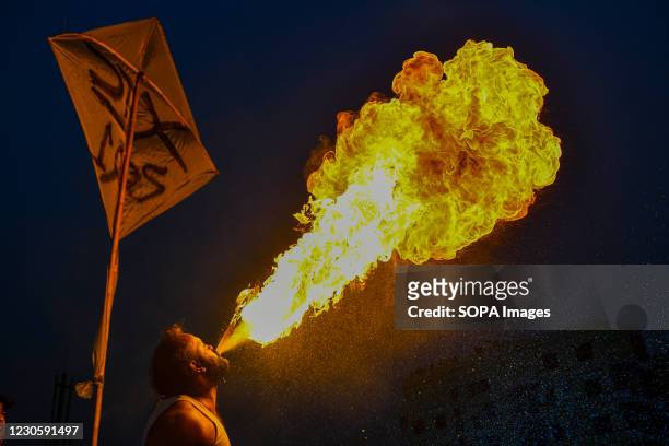 Bangladeshi people perform fire breathing on their rooftop during Shakrain festival or the Kite festival. Shakrain Festival is an annual celebration...