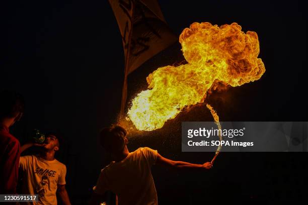 Bangladeshi people perform fire breathing on their rooftop during Shakrain festival or the Kite festival. Shakrain Festival is an annual celebration...