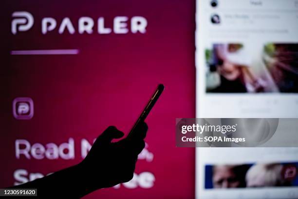 In this photo illustration a Parler website is seen behind a cell phone. The 'free speech' social media platform, Parler, a hit with Trump supporters...