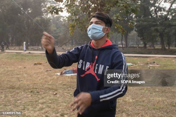 Boy prepares to fly a kite on the occasion of Shakrain festival. Shakrain Festival also known as Kite festival is an annual celebration of winter in...