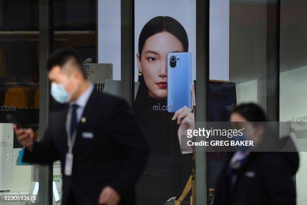 People walk past a Xiaomi store in Beijing on January 15 as shares in the company collapsed on January 15 after the United States blacklisted the...