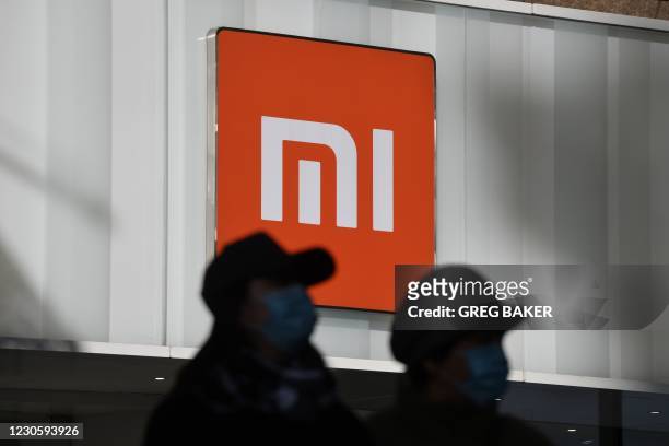 Two women walk past a Xiaomi store in Beijing on January 15 as shares in the company collapsed on January 15 after the United States blacklisted the...