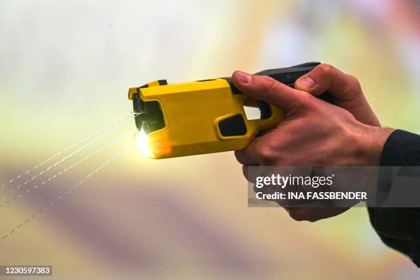 Police officer demonstrates the use of a distance electro-pulse device TASER 7 after a press conference in Dortmund, western Germany, on January 15,...