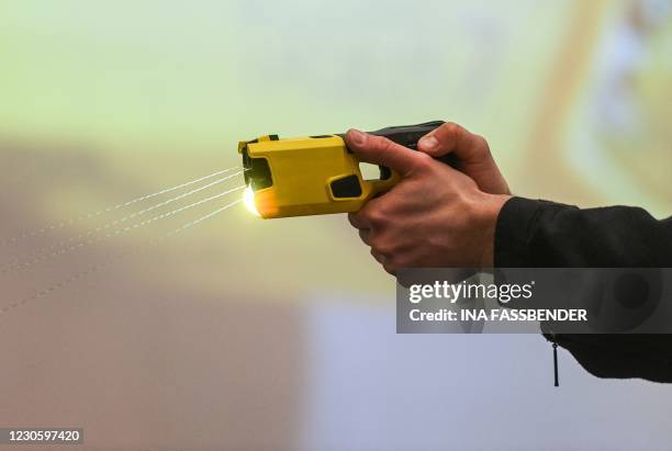 Police officer demonstrates the use of a distance electro-pulse device TASER 7 after a press conference in Dortmund, western Germany, on January 15,...