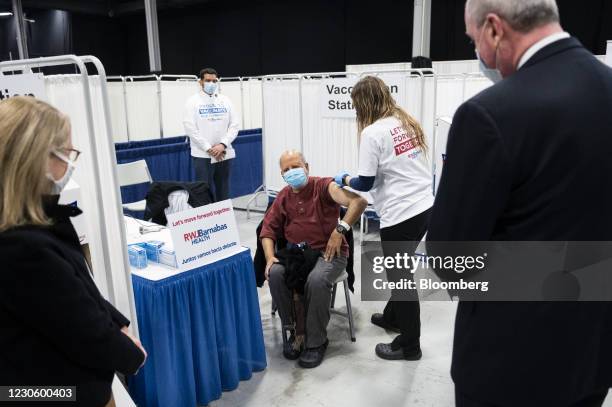 Phil Murphy, New Jersey's governor, right, watches as a person receives a dose of a Covid-19 vaccination at the New Jersey Convention and Exposition...