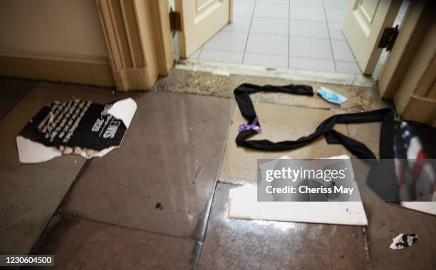 Remnants of a sign honoring civil rights icon, former U.S. Rep. John Lewis , lays ripped on the floor inside the U.S. Capitol after they cleared a...