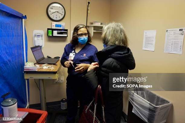 Medical assistant Adrienne Coleman schedules a second appointment after administering the first dose of Pfizer-BioNTech COVID-19 vaccine to Bette...