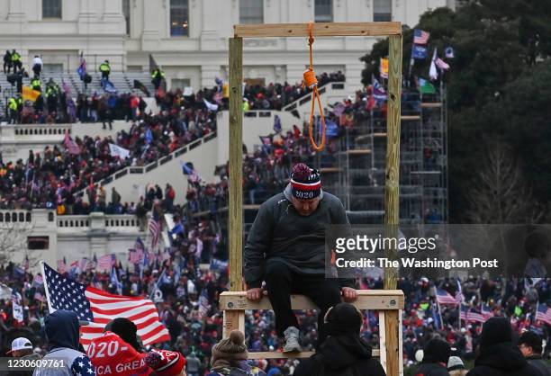 Man climbs down after being photographed with a noose during a protest calling for legislators to overturn the election results in President Donald...