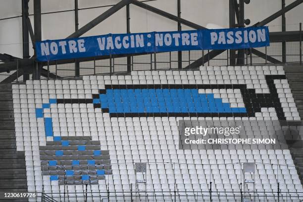 Picture shows seats fitted with coloured sheets to depict a syringe and the Covid-19 coronavirus and a banner reading "Our Vaccine: Our passion" in...