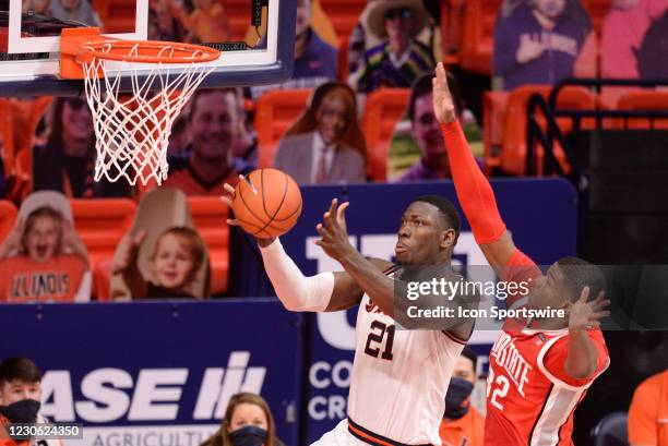 Illinois Fighting Illini center Kofi Cockburn passes the ball from as he jumps around Ohio State Buckeyes forward E.J. Liddell during the Big Ten...