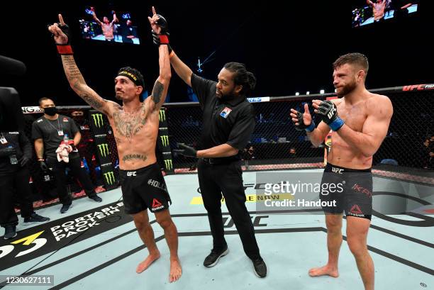 In this handout image provided by UFC, Max Holloway celebrates after his unanimous-decision victory over Calvin Kattar in a featherweight bout during...