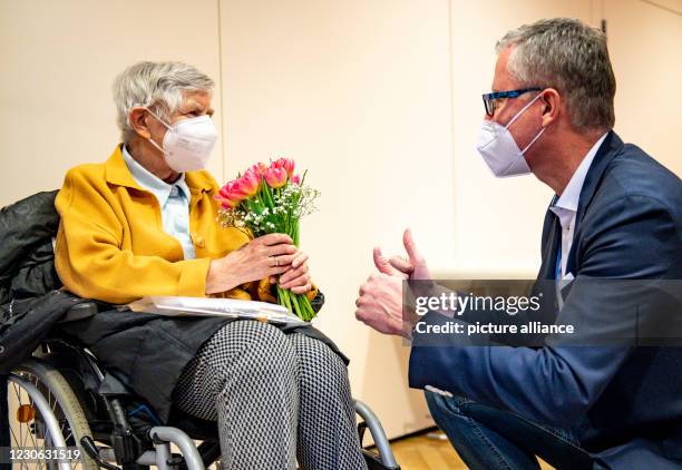 January 2021, Hamburg: After her second Corona vaccination, 84-year-old Karin Sievers receives a bouquet of flowers from Frank Schubert, chairman of...