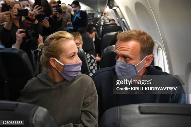 Russian opposition leader Alexei Navalny and his wife Yulia sit in a Pobeda airlines plane heading to Moscow before take-off from Berlin Brandenburg...