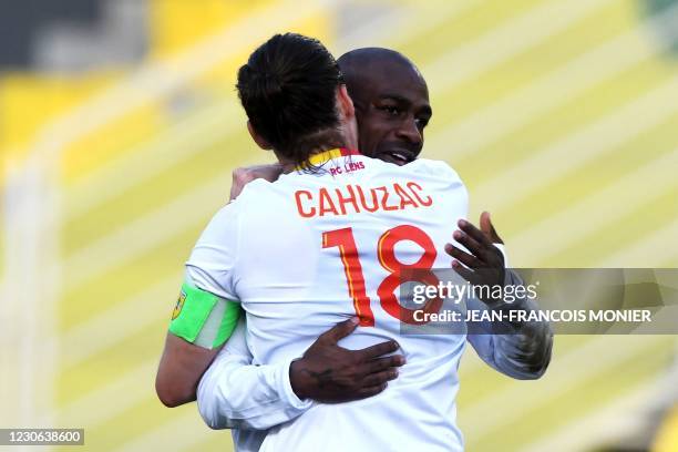 Lens' French midfielder Yannick Cahuzac congratulates Lens' French Congolese defender Gael Kakuta after scoring during the French L1 Football match...