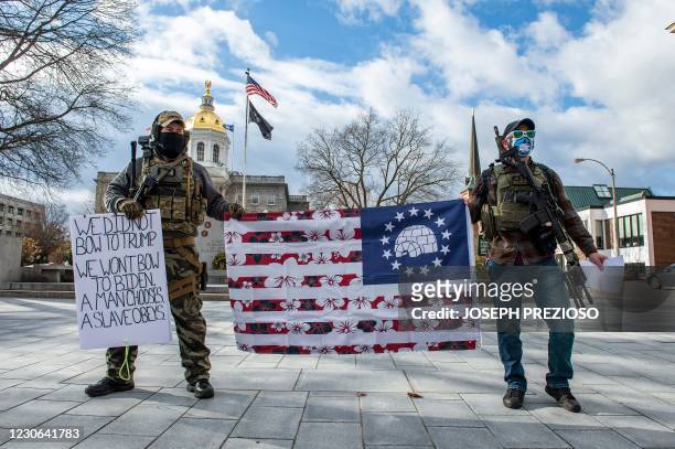 Armed members of the Boogaloo militia stand holding a flag in front of the State Capital in Concord, New Hampshire on January 17 during a nationwide...