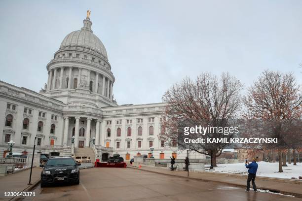 Man takes a picture of the police cars in front of the State Capitol in Madison, Wisconsin, on January 17 during a nationwide protest called by...