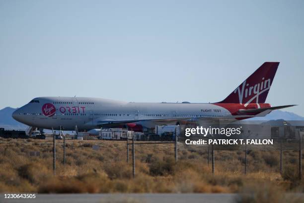 The Virgin Orbit "Cosmic Girl" - a modified Boeing Co. 747-400 carrying a LauncherOne rocket under it's wing - is prepared on the tarmac for the...