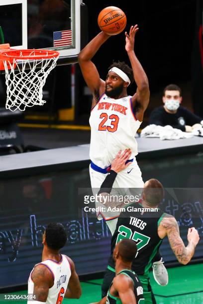 Mitchell Robinson of the New York Knicks slam dunks the ball over Daniel Theis of the Boston Celtics during a game at TD Garden on January 17, 2021...