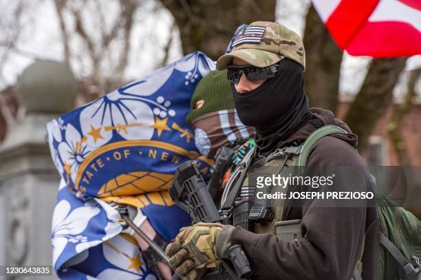 Armed members of the Boogaloo militia stand with their flags in front of the State Capital in Concord, New Hampshire on January 17 during a...