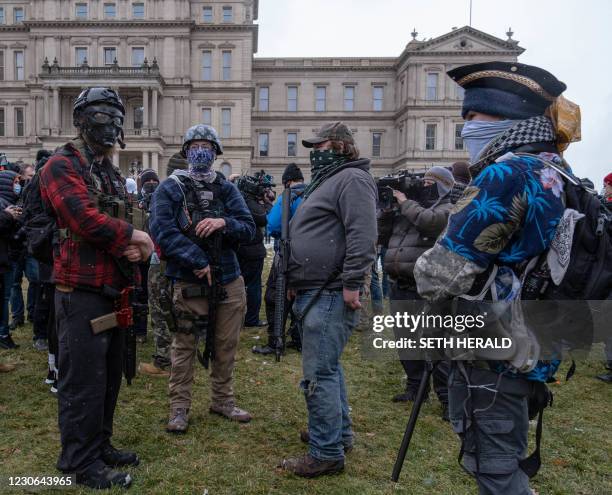 Members of the Michigan Boogaloo Bois an anti-government group stand with their long guns near the Capitol Building in Lansing, Michigan on January...