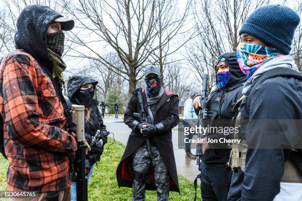 Right-wing and left-wing members of the armed militia known as the Boogaloo Boys converse near the Capitol Building on January 17, 2021 in Frankfort,...