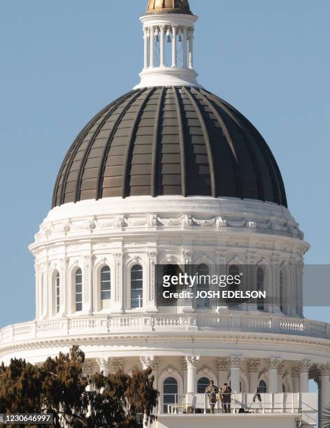 Members of the National Guard keep watch from atop a balcony at the State Capitol in Sacramento, California on January 17, 2021 during a nationwide...