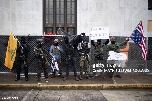 Members of the Boogaloo Boys pose for photographers outside the Oregon Sate Capitol Building in Salem on January 17 during a nationwide protest...