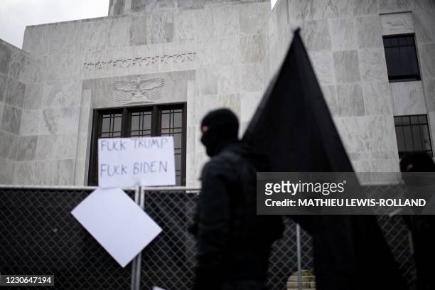 Member of the Boogaloo Boys stands armed in front of the Oregon Sate Capitol Building in Salem on January 17 during a nationwide protest called by...