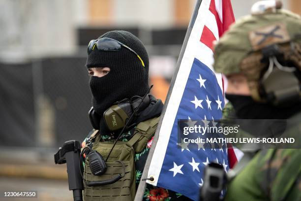 Members of the Boogaloo Boys stand armed in front of the Oregon Sate Capitol building in Salem on January 17 during a nationwide protest called by...
