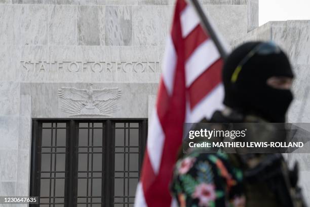 Member of the Boogaloo Boys stands armed in front of the Oregon Sate Capitol building in Salem on January 17 during a nationwide protest called by...