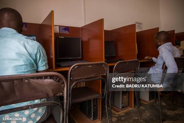 Men use computers at a cyber cafe minutes after the Uganda Communication Commission, a body responsible for communications in Uganda, restored the...