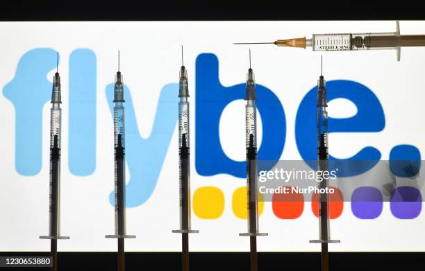 An illustrative image of medical syringes in front of a FlyBe logo displayed on a screen. On Monday, January 18 in Dublin, Ireland.