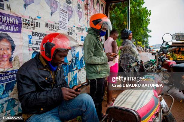 People using internet on phones at a taxi waiting area minutes after the Uganda Communication Commission, a body responsible for communications in...