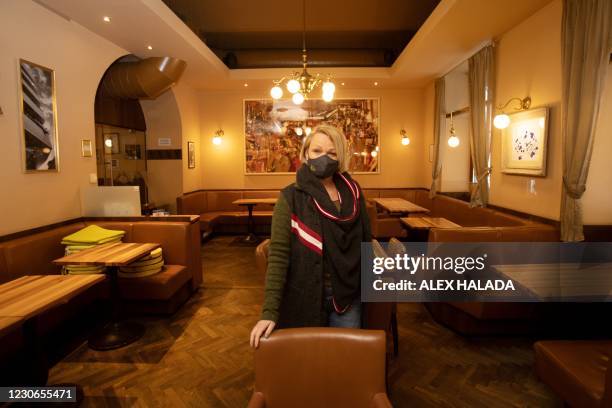 The owner of Cafe Hummel, Christina Hummel, poses for photos in the empty restaurant in Vienna on January 18 amid the novel coronavirus pandemic. -...