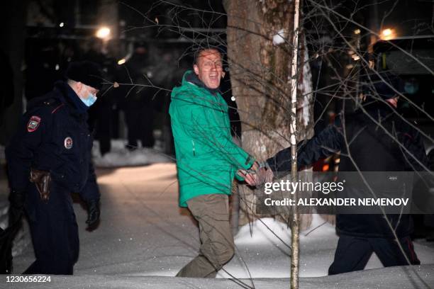 Opposition leader Alexei Navalny is escorted out of a police station on January 18 in Khimki, outside Moscow, following the court ruling that ordered...