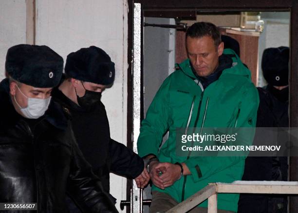 Opposition leader Alexei Navalny is escorted out of a police station on January 18 in Khimki, outside Moscow, following the court ruling that ordered...