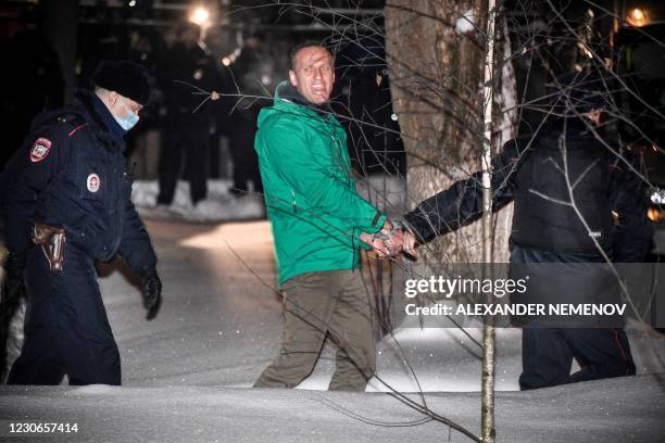 Opposition leader Alexei Navalny is escorted out of a police station on January 18 in Khimki, outside Moscow, following the court ruling that ordered...