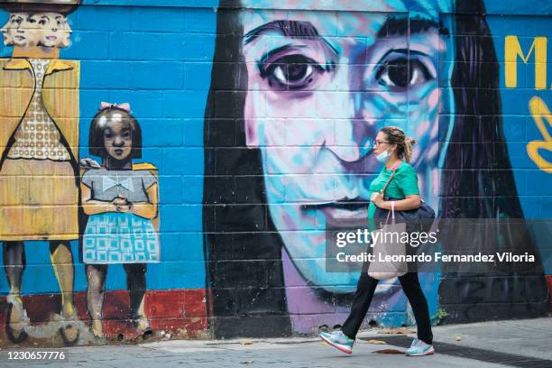 Woman wearing a protective mask on her chin on walks near the Bolivar square in the city center during a week of total lockdown as part of 7+7 plan...