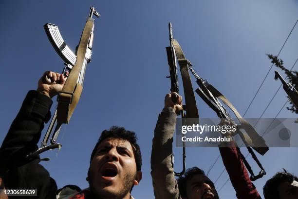 Young supporters of Yemen's Huthi movement raise their fists up as they chant slogans during a demonstration in front of the closed US Embassy in the...