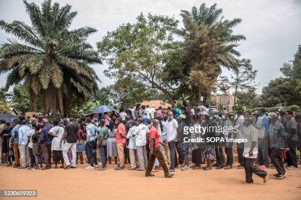 Voters line up at the opposition leader Bobi Wine whose real name is Robert Kyagulanyi's local polling station in Magere, on the outskirts of...