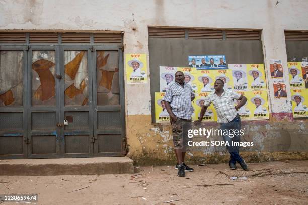 Men stand in front of posters of Yoweri Museveni, Uganda's long-time president. Uganda's elections, on January 14 were the most tense in decades.