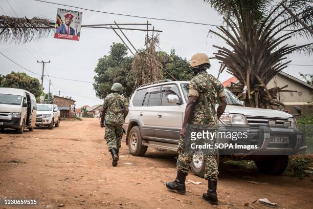 Soldiers walk towards the home of the opposition leader Bobi Wine whose real name is Robert Kyagulanyi, two days after Uganda's presidential...