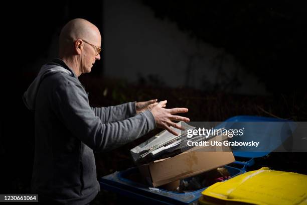 Bonn, Germany In this photo illustration a man throws used paper in a wastes can on January 17, 2021 in Bonn, Germany.