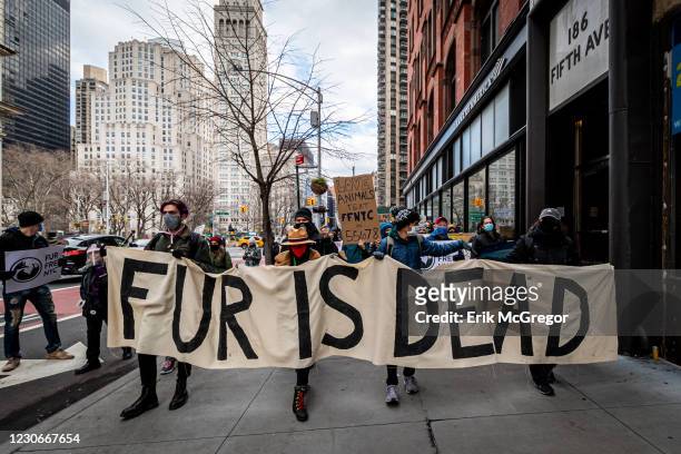 Animal rights activists seen holding a banner as they march through the streets of New York. Hundreds of Animal Rights activists targeted the...